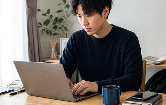 自宅でノートパソコンに向かう男性
