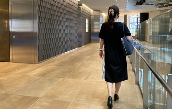 建物の廊下を歩いて退勤する女性スタッフ